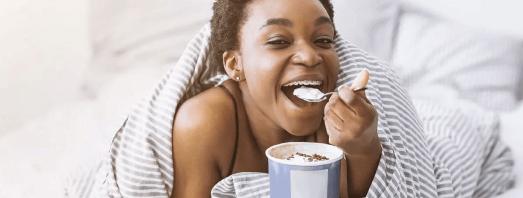 Foods With Braces Header - Teen Eating Ice Cream In Bed